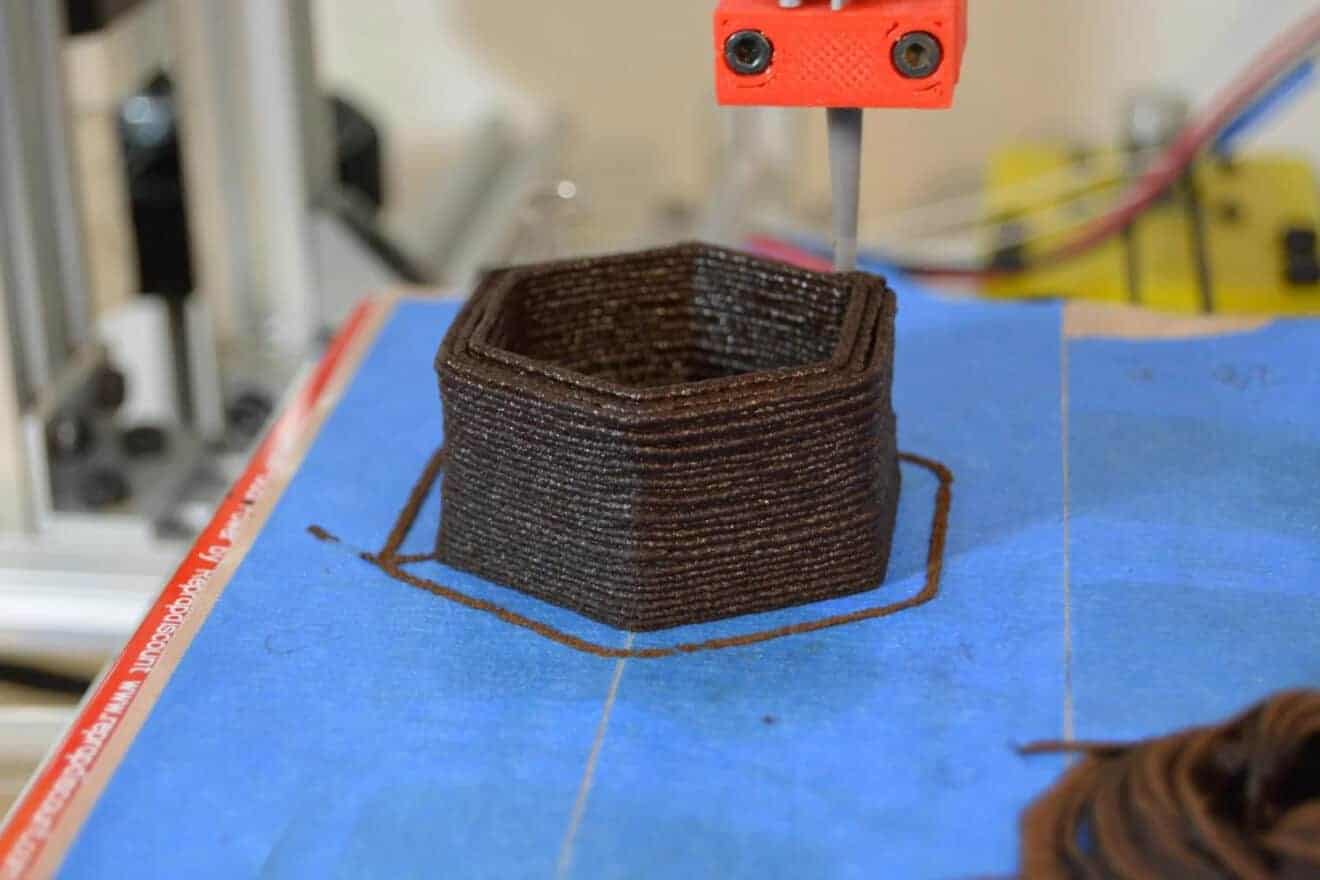 A 3D printer lays down used coffee grounds to make a flower pot