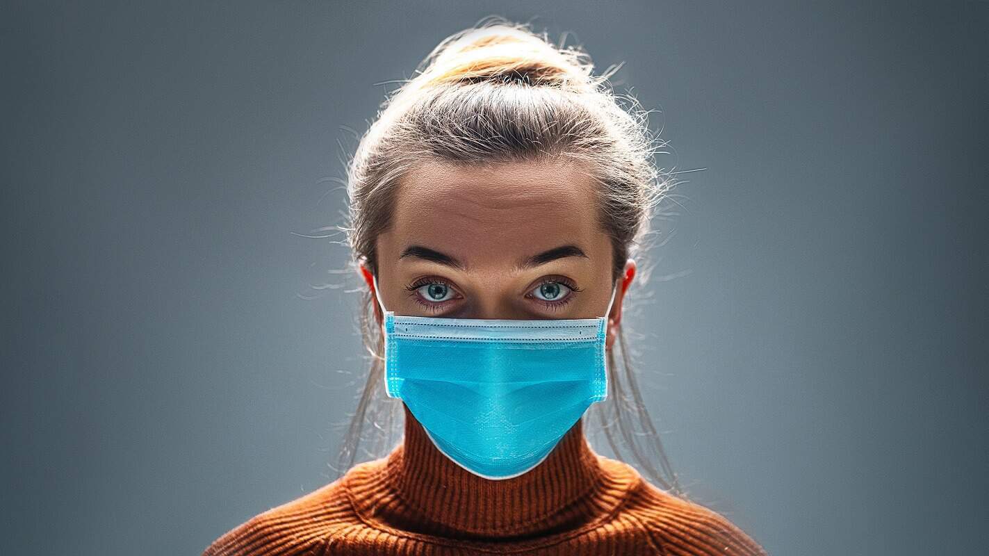 Woman wearing blue medical protective mask to health protection from influenza virus, epidemic and infectious diseases