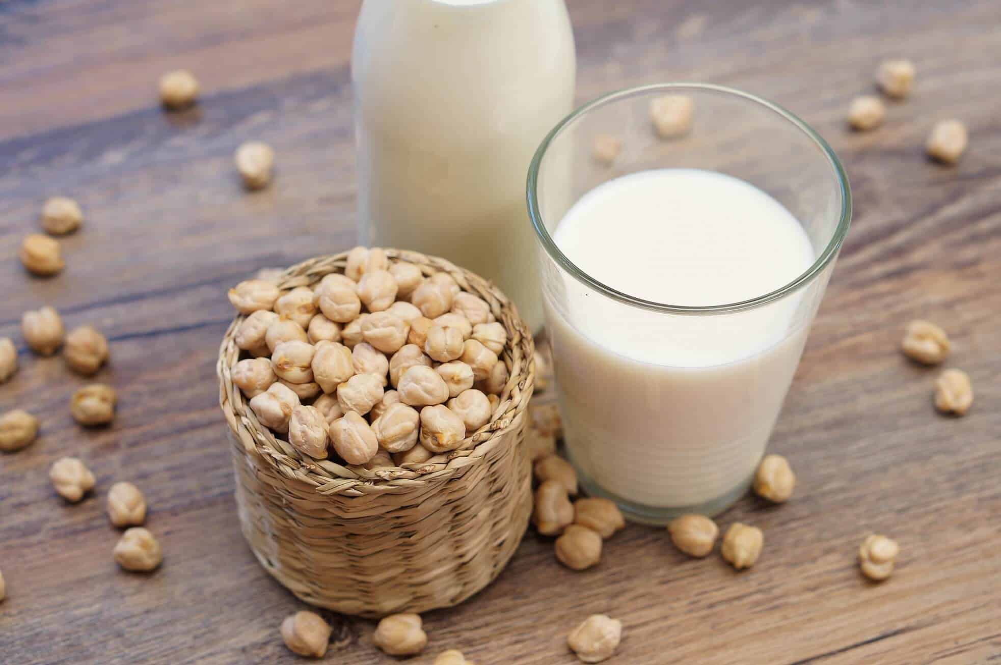 chickp's milk in a glass with a cup of raw whole chickpeas 