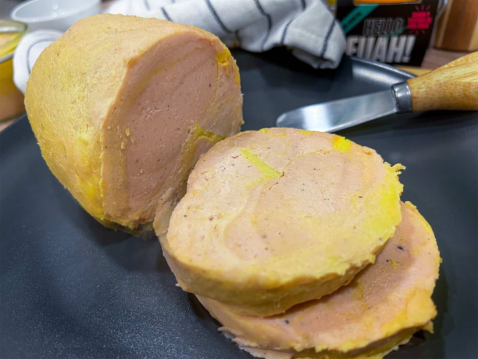 Hola foie gras vegano en rodajas sobre un plato negro