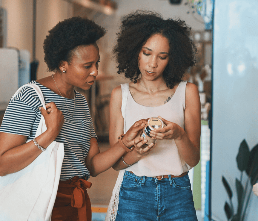 two woman reading a product label