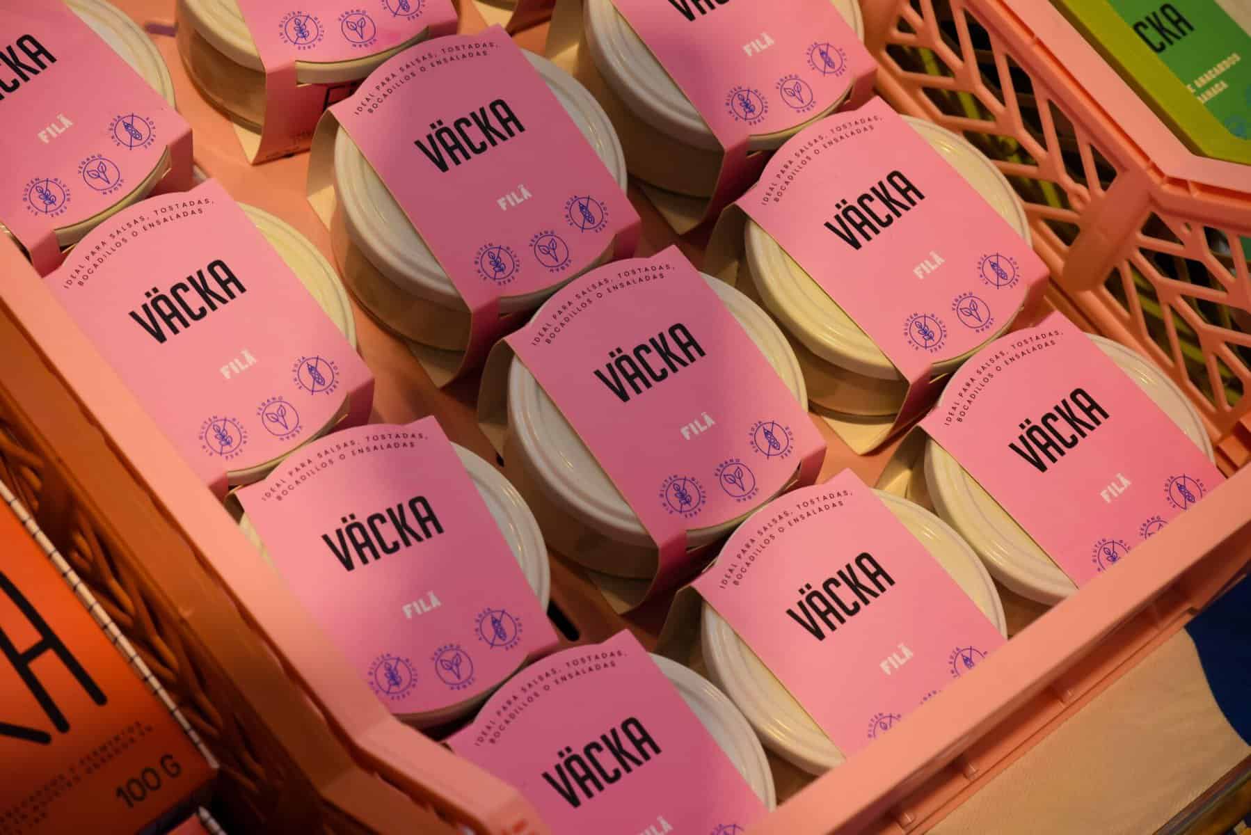 many spanish vegan cheese products with a pink label organised inside a plastic box