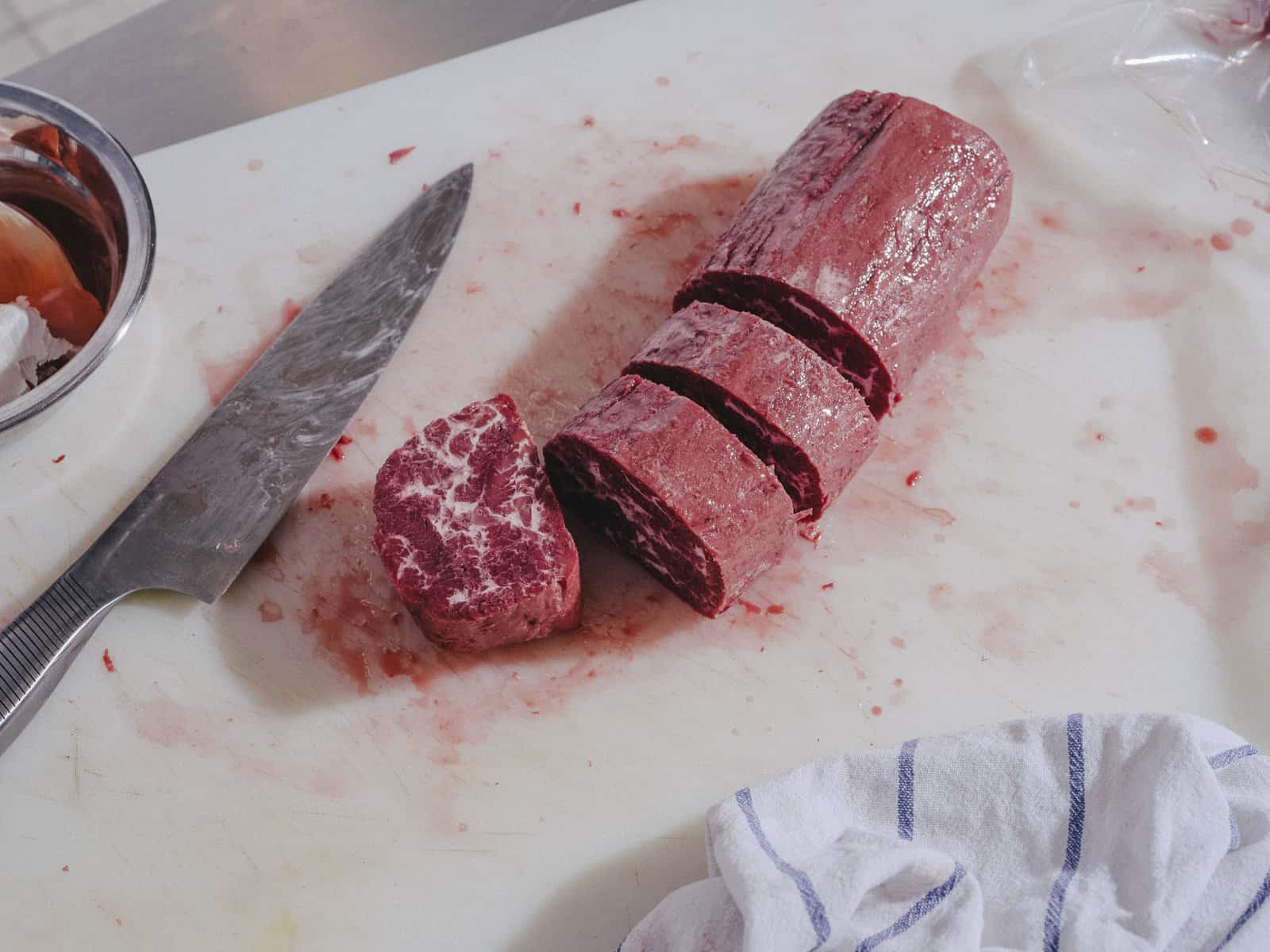 Juicy Marbles' plant-based raw whole cut loin being cut in a board